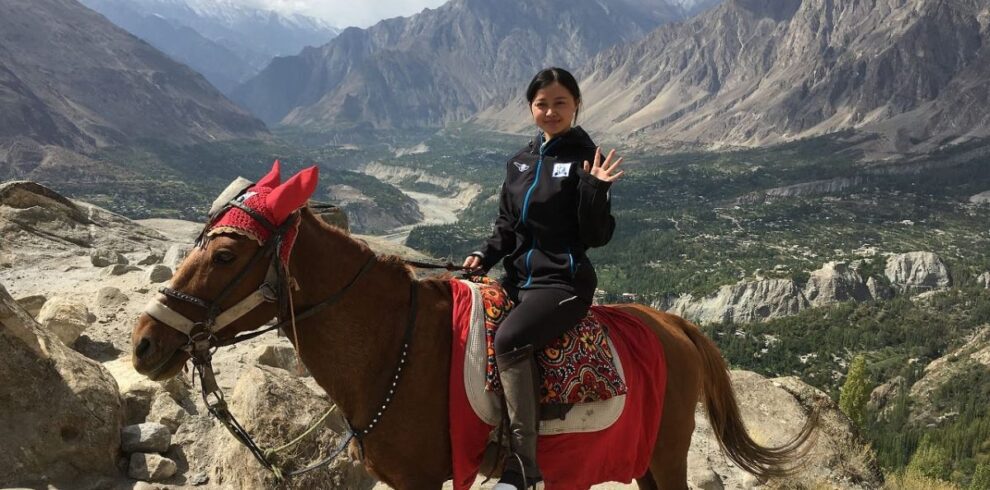 Traveler enjoying horse riding in North Pakistan during a scenic northern Pakistan tour through lush green valleys and mountain trails