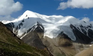 Trekker ascending snow-covered mountain in the Karakoram range