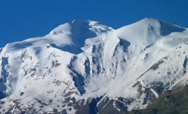 Camp setup below a snow-draped trekking peak